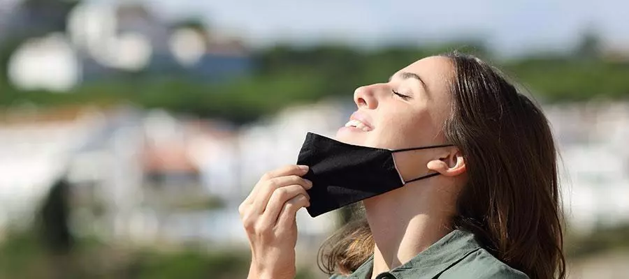 Mujer al aire libre retirándose la mascarilla
